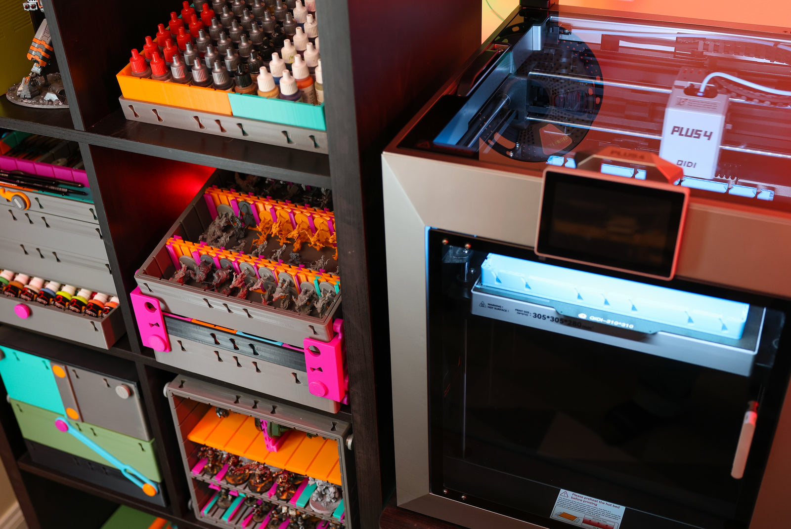 A creative workspace featuring a QIDI 3D printer producing colorful 3D printed items.