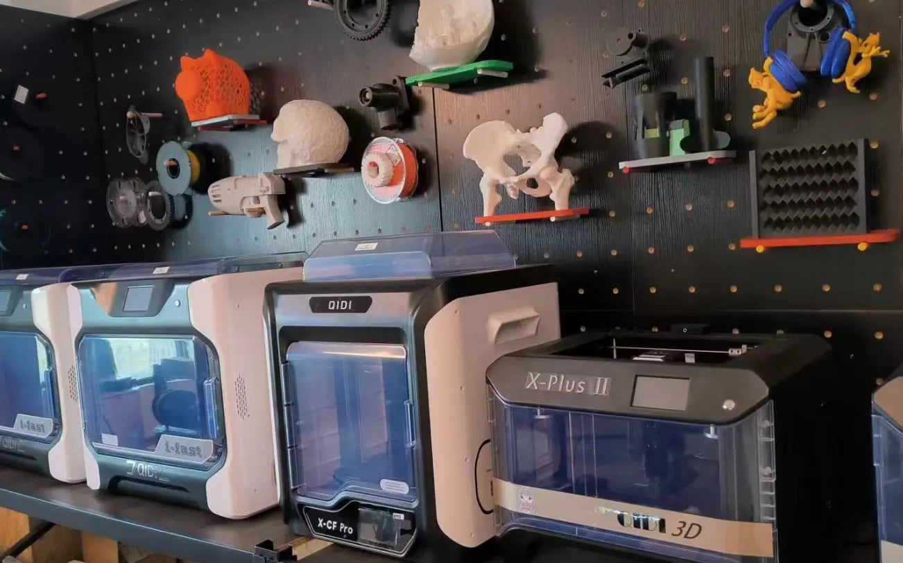 A 3D printing studio with a row of 3D printers on the table and many 3D printed works hanging on the walls.