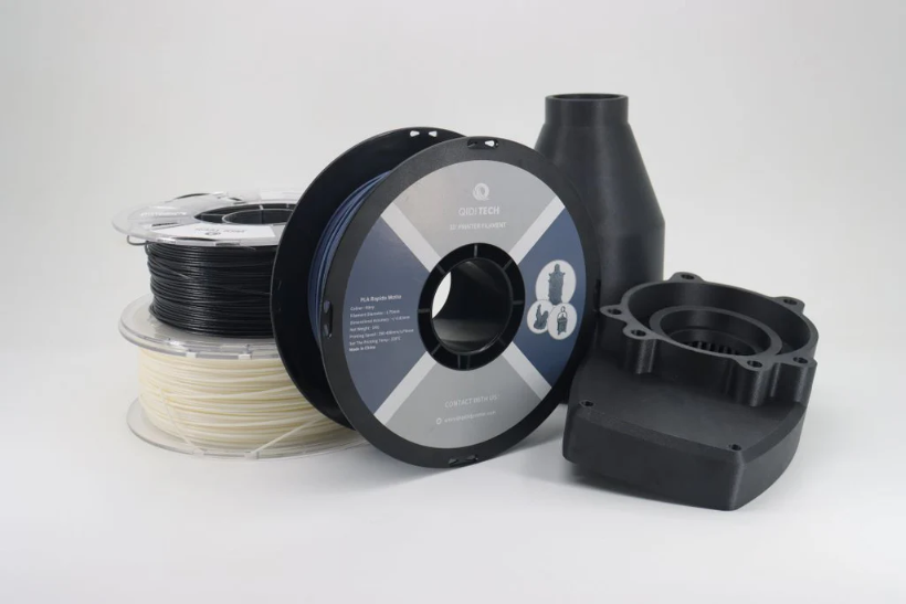 A spool of black QIDI TECH 3D printing filament on a white background.