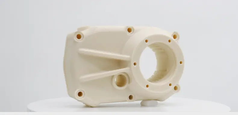 A 3D printed white mechanical part with multiple circular holes, a larger circular opening, and several reinforcing ribs.