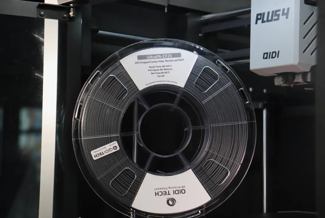QIDI UltraPA-CF25 3D printer spools displayed inside the printer room, showing professional grade black carbon fiber reinforced nylon material, spool storage and setup for industrial printing applications