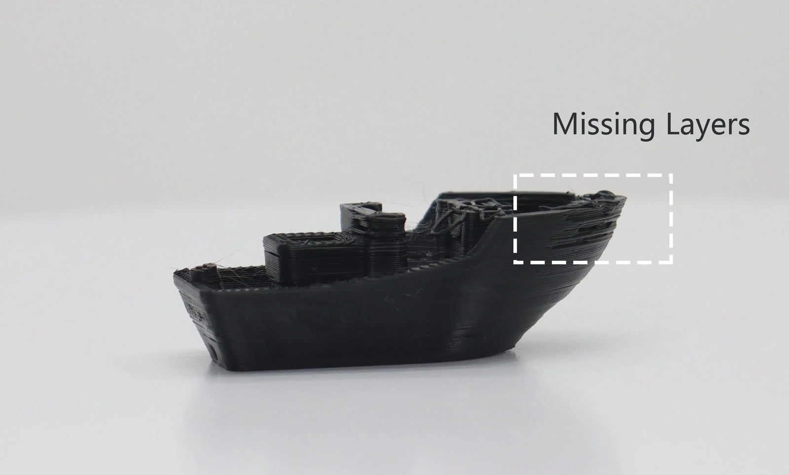 Black 3D Benchy model with a highlighted box showing missing layers on the hull, illustrating under-extrusion print defects.