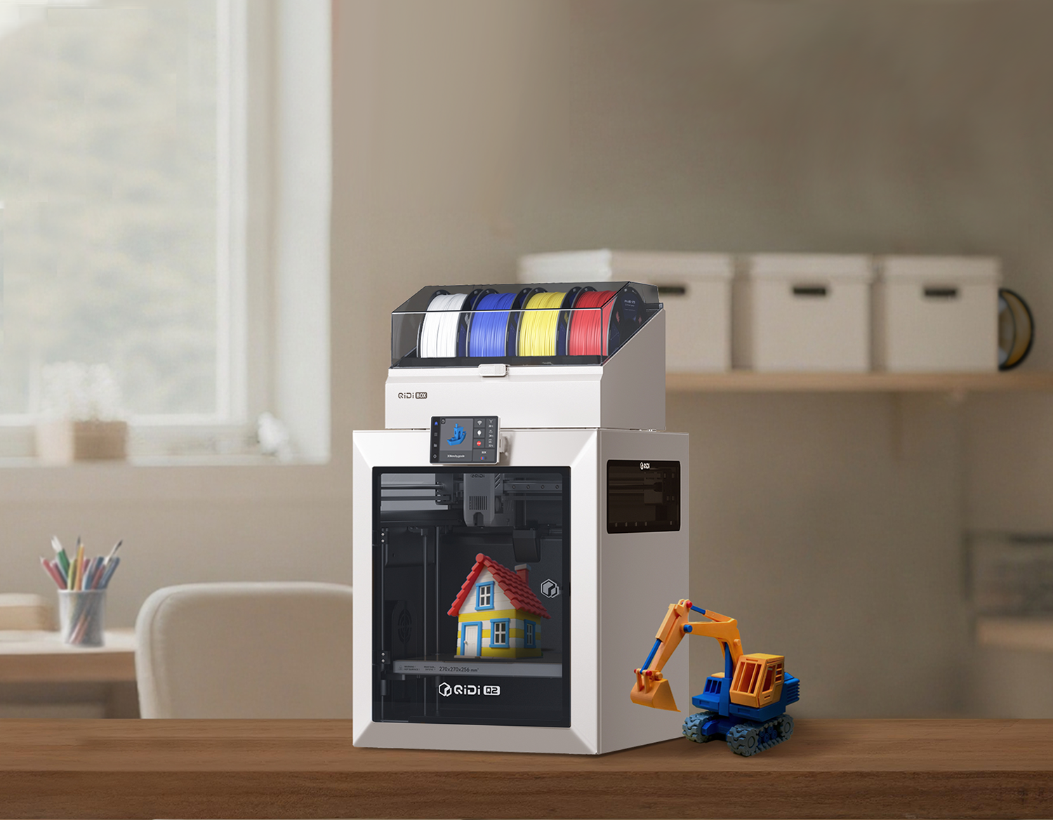 QIDI desktop 3D printer with multi-color filaments printing a colorful house model, toy excavator nearby.